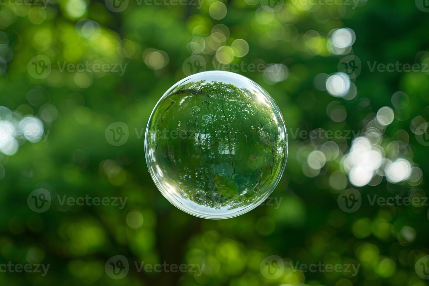 Soap bubble floating in the air reflecting green trees photo