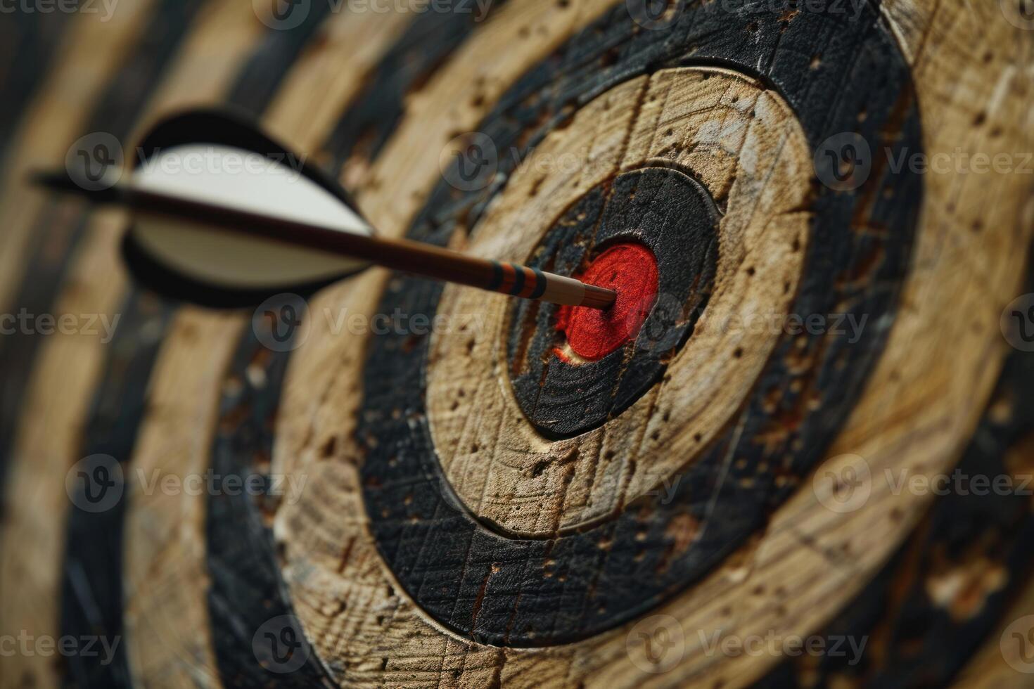 Arrow hitting the center of an old target on wooden background photo