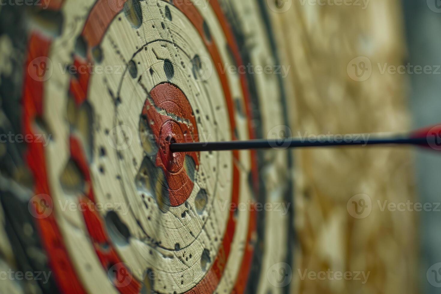 Arrow hitting the center of an old target on wood background photo