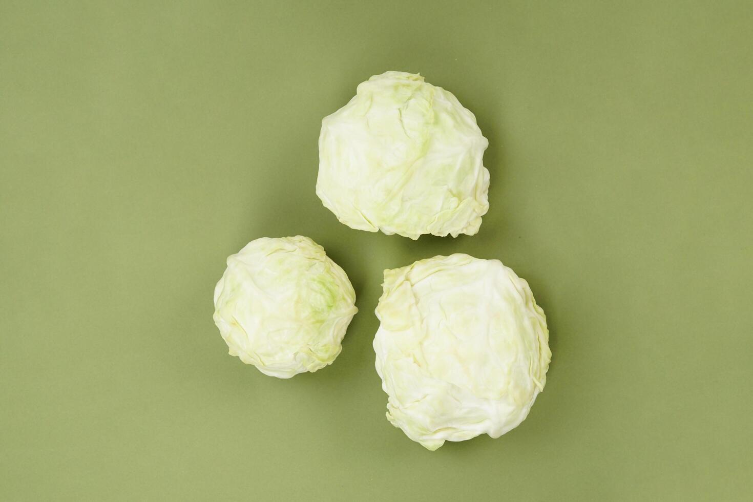 Fresh ripe cabbage vegetable isolated on a green background photo