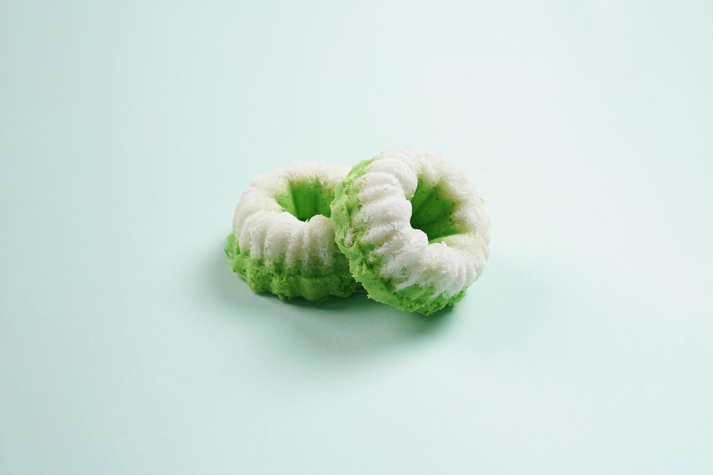 Putu ayu isolated on green background. It is a traditional dessert made from steamed rice flour and topped with grated coconut, a classic Indonesian cake photo