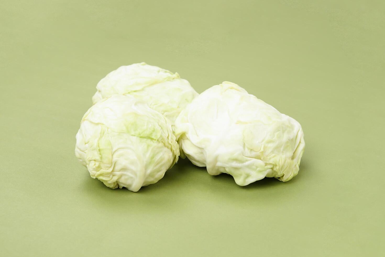 Fresh ripe cabbage vegetable isolated on a green background photo