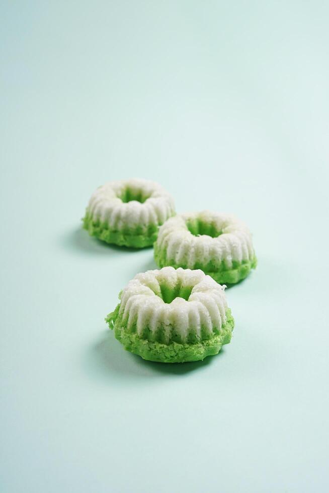 Putu ayu isolated on green background. It is a traditional dessert made from steamed rice flour and topped with grated coconut, a classic Indonesian cake photo