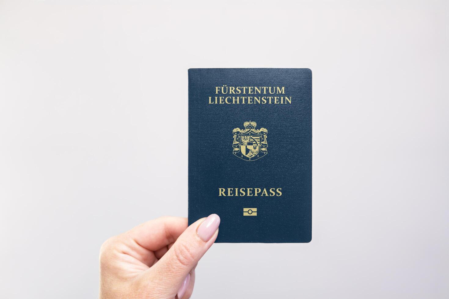 Liechtenstein Passport Held Against Simple White Background. Astana, Kazakhstan, 26 october 2024 photo