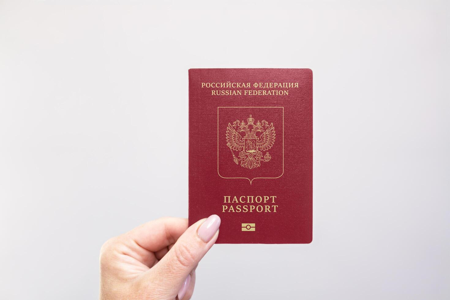 Passport Held Against Simple White Background. Astana, Kazakhstan, 26 october 2024 photo