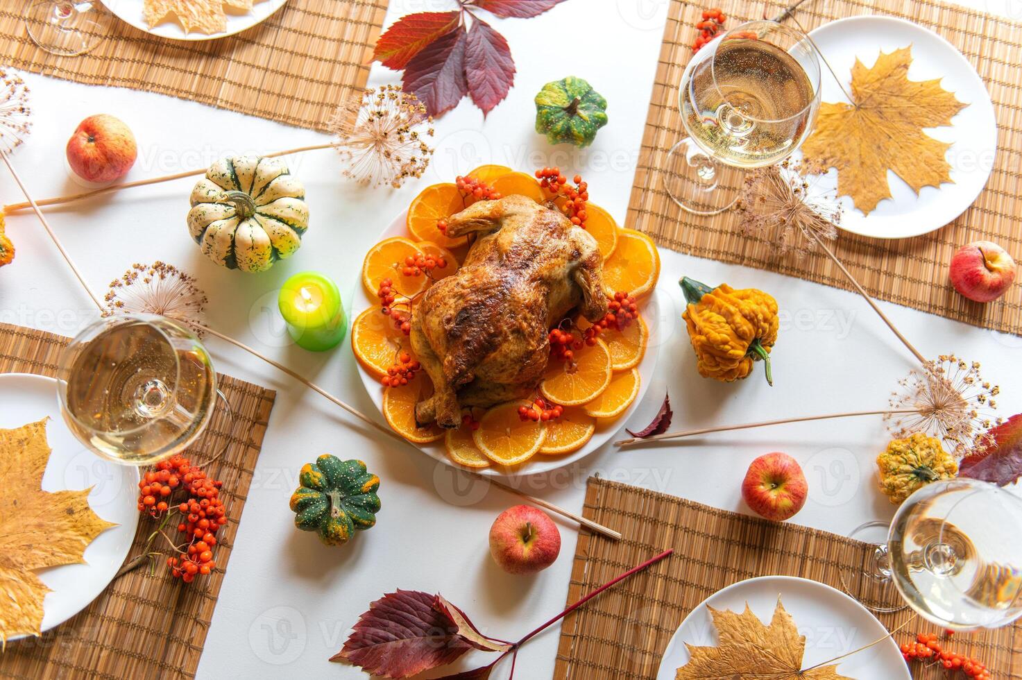 Festive thanksgiving dinner table is set with a roasted turkey as the centerpiece, top view photo