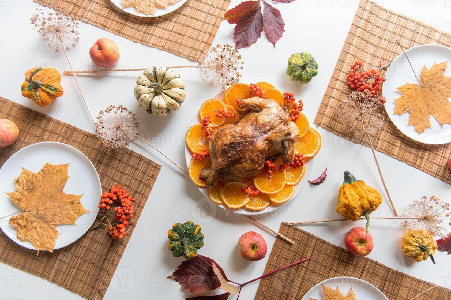 Festive thanksgiving dinner table is set with a roasted turkey as the centerpiece photo