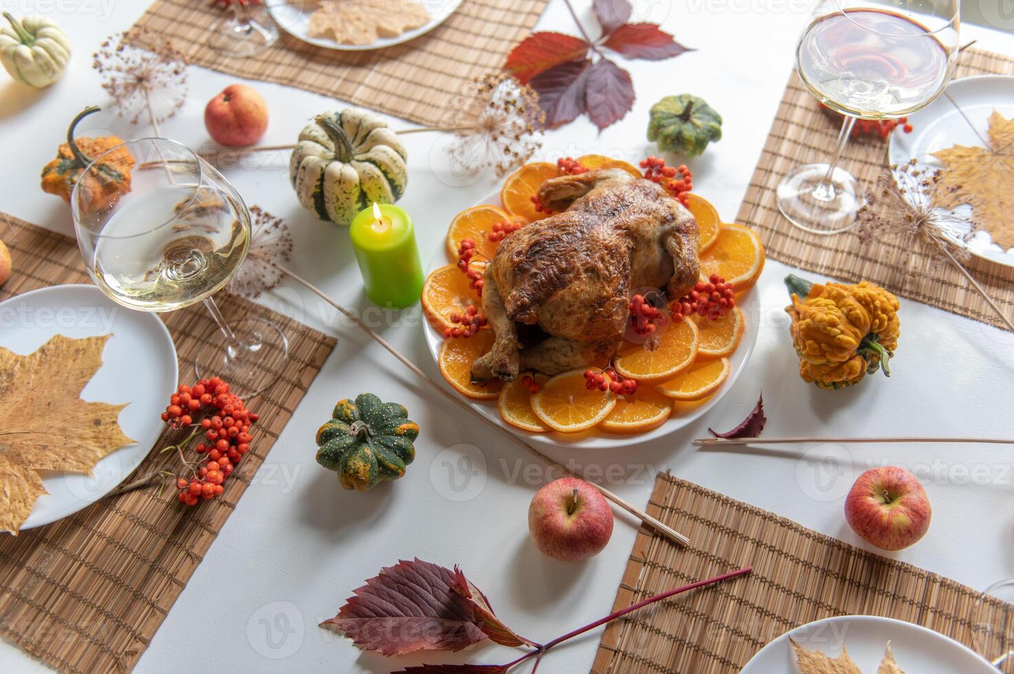Thanksgiving table setting with decorations, pumpkins, glasses and plates. photo