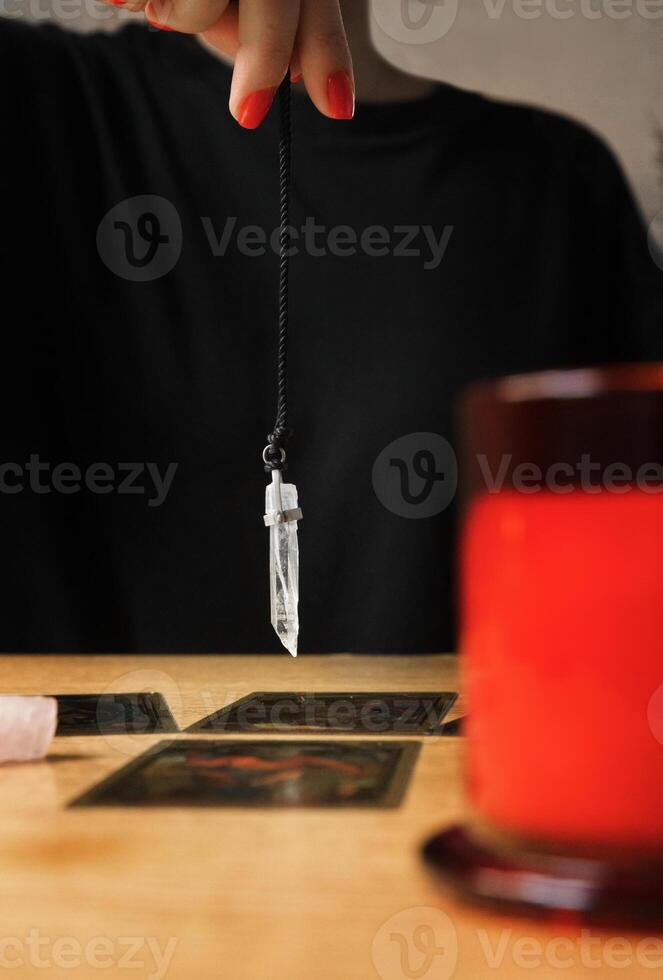 Female fortune teller predicting fate, reading tarot cards, pendulum. Selective focus. High quality photo