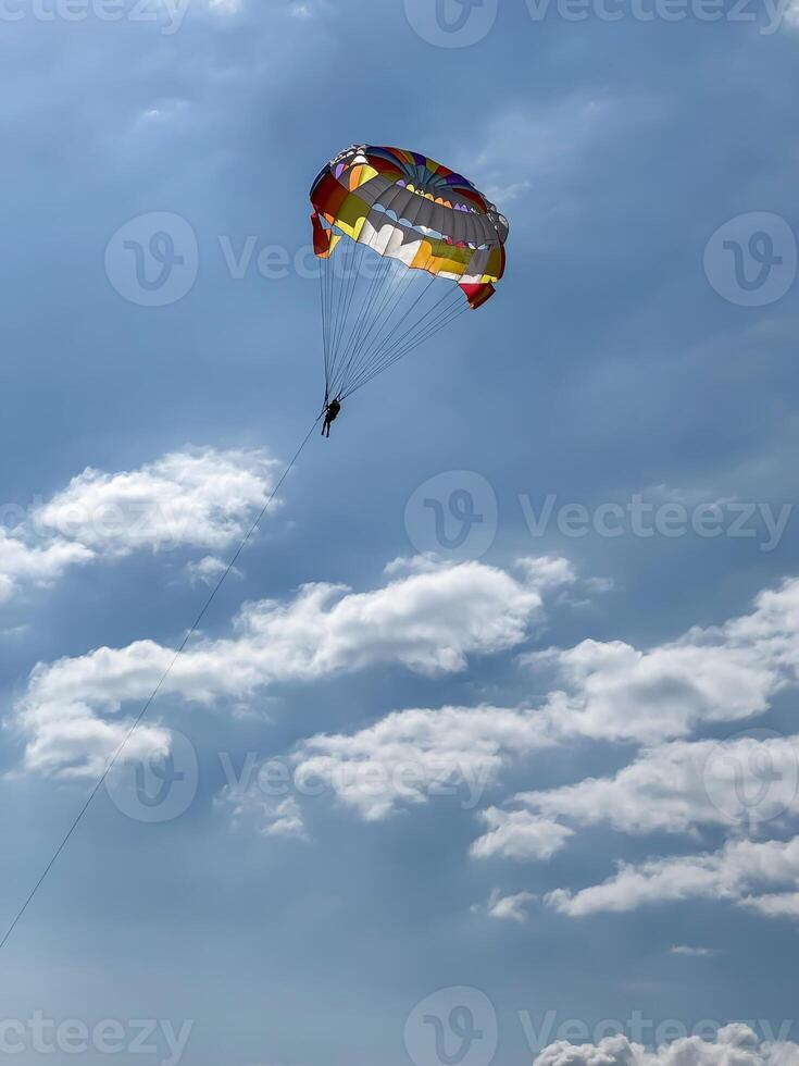Parasailing in a clear blue sky with clouds. High quality photos
