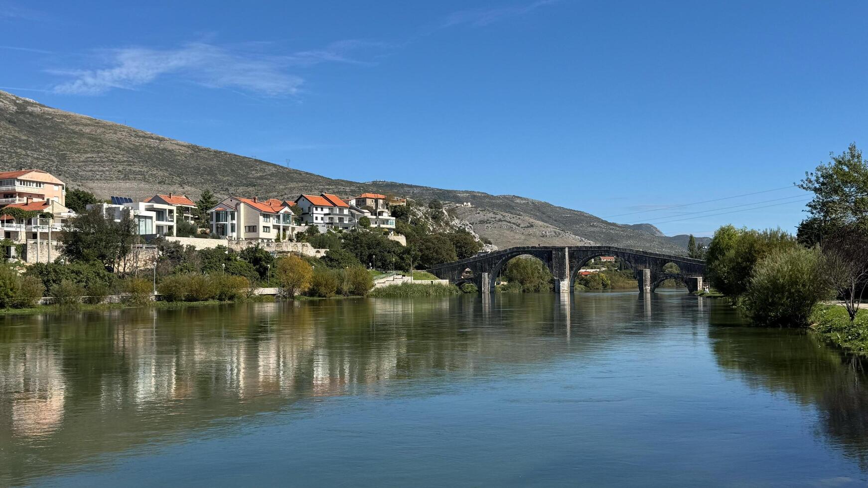 The cityscape on the Trebisnica River and the old bridge. Trebinje, Bosnia and Herzegovina, 2 October 2024 photo