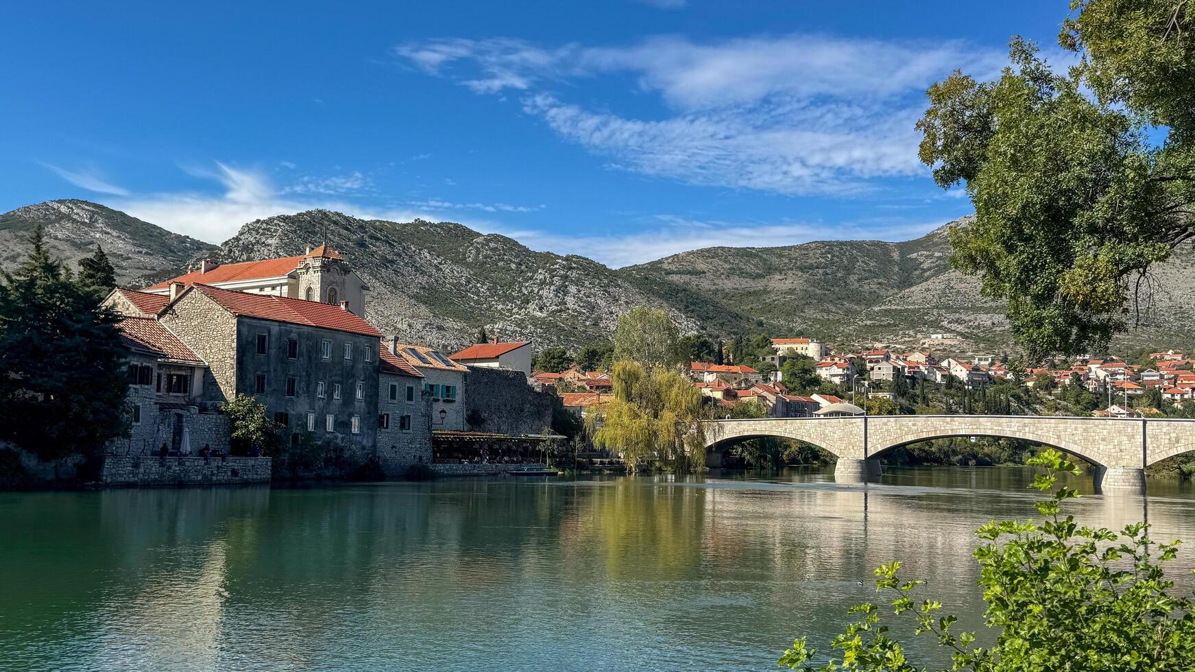 The cityscape and the bridge, as seen from the Trebisnica River. Trebinje, Bosnia and Herzegovina, 2 October 2024 photo