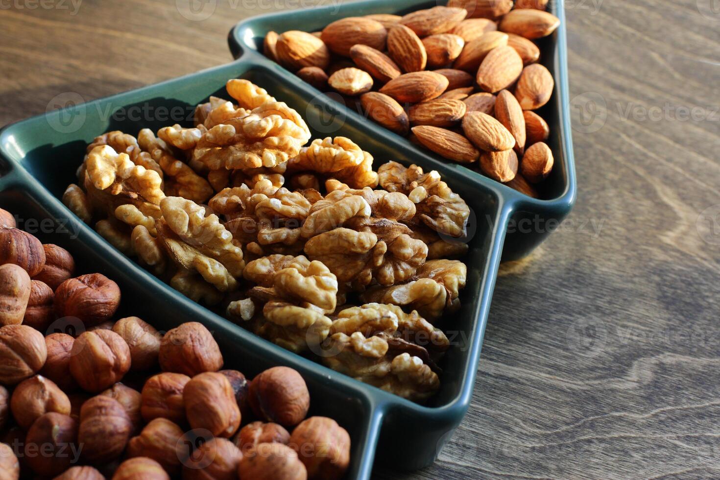 different types of nuts, Various snacks for the New Year table in a plate in the shape of a Christmas tree. photo