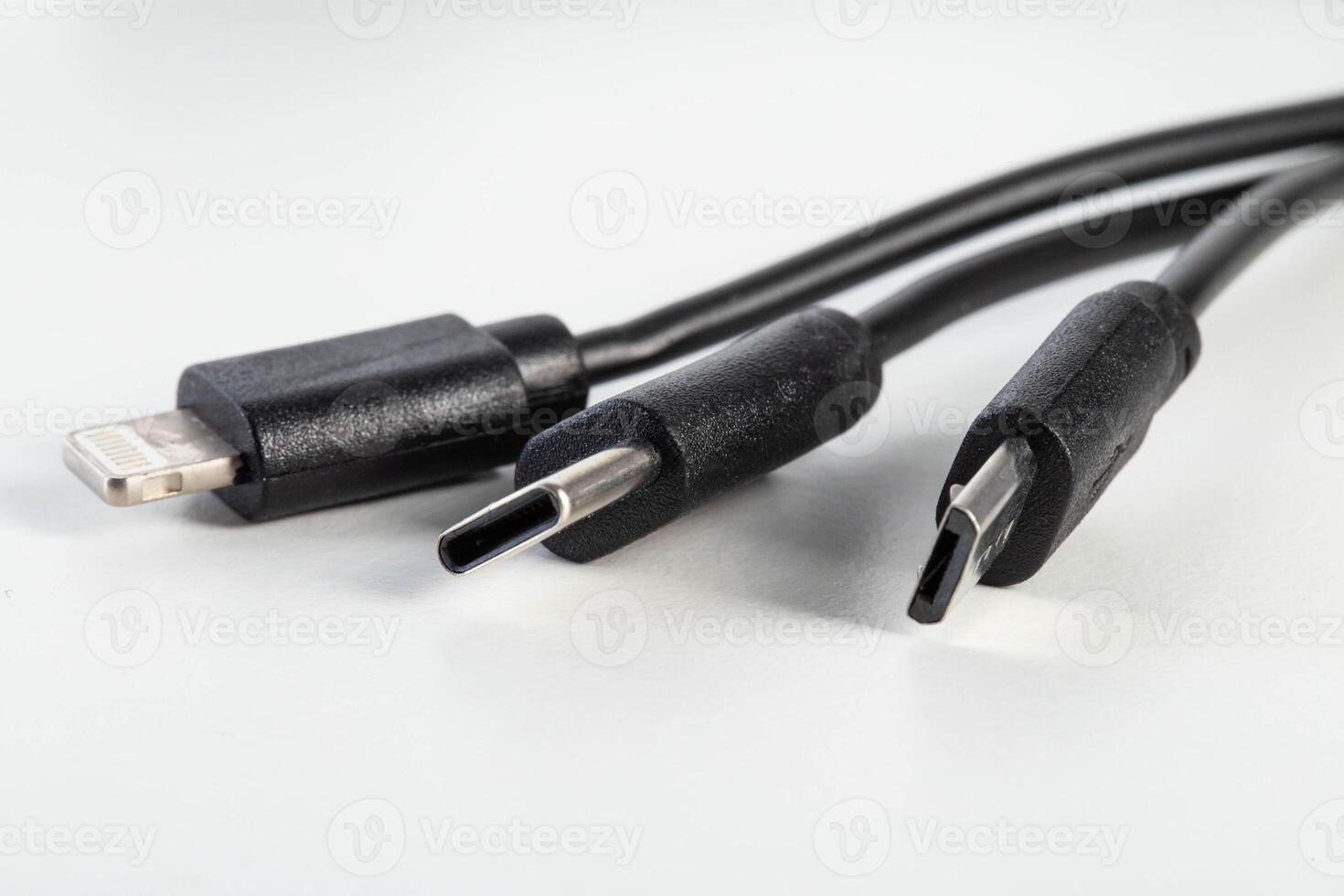 Universal black 3 in 1 charging cable with different charging connectors on a white background, close-up. Type-c, usb-c, micro-usb photo