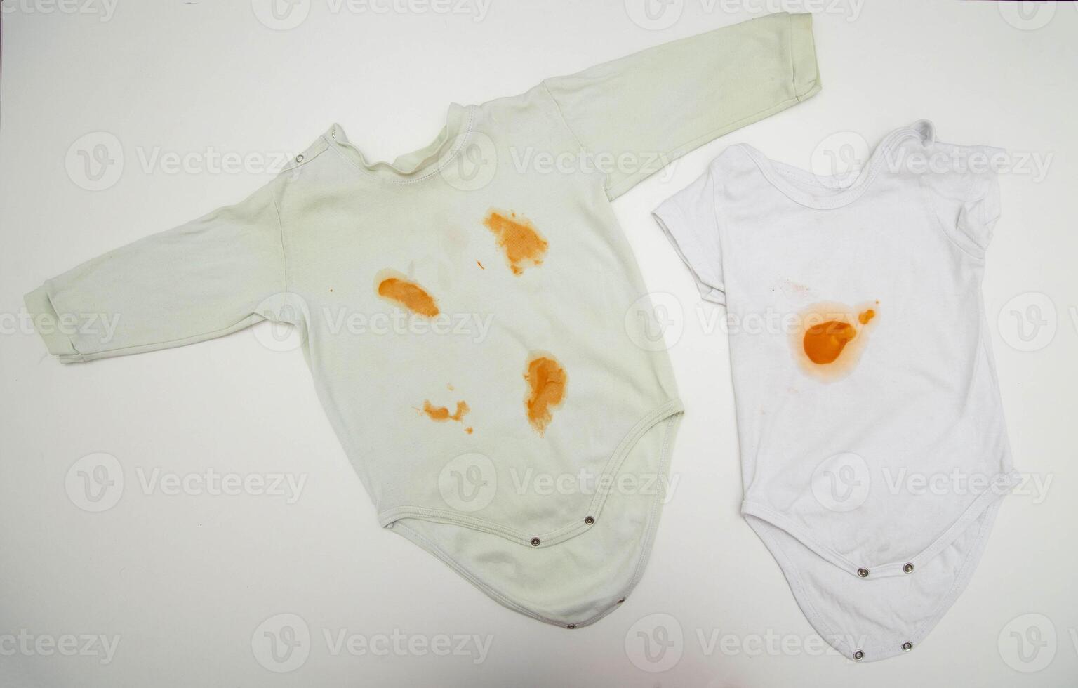 Orange stains on children's clothes from fruit puree. The concept of cleaning stains on clothes with an oxygen stain remover, close-up photo