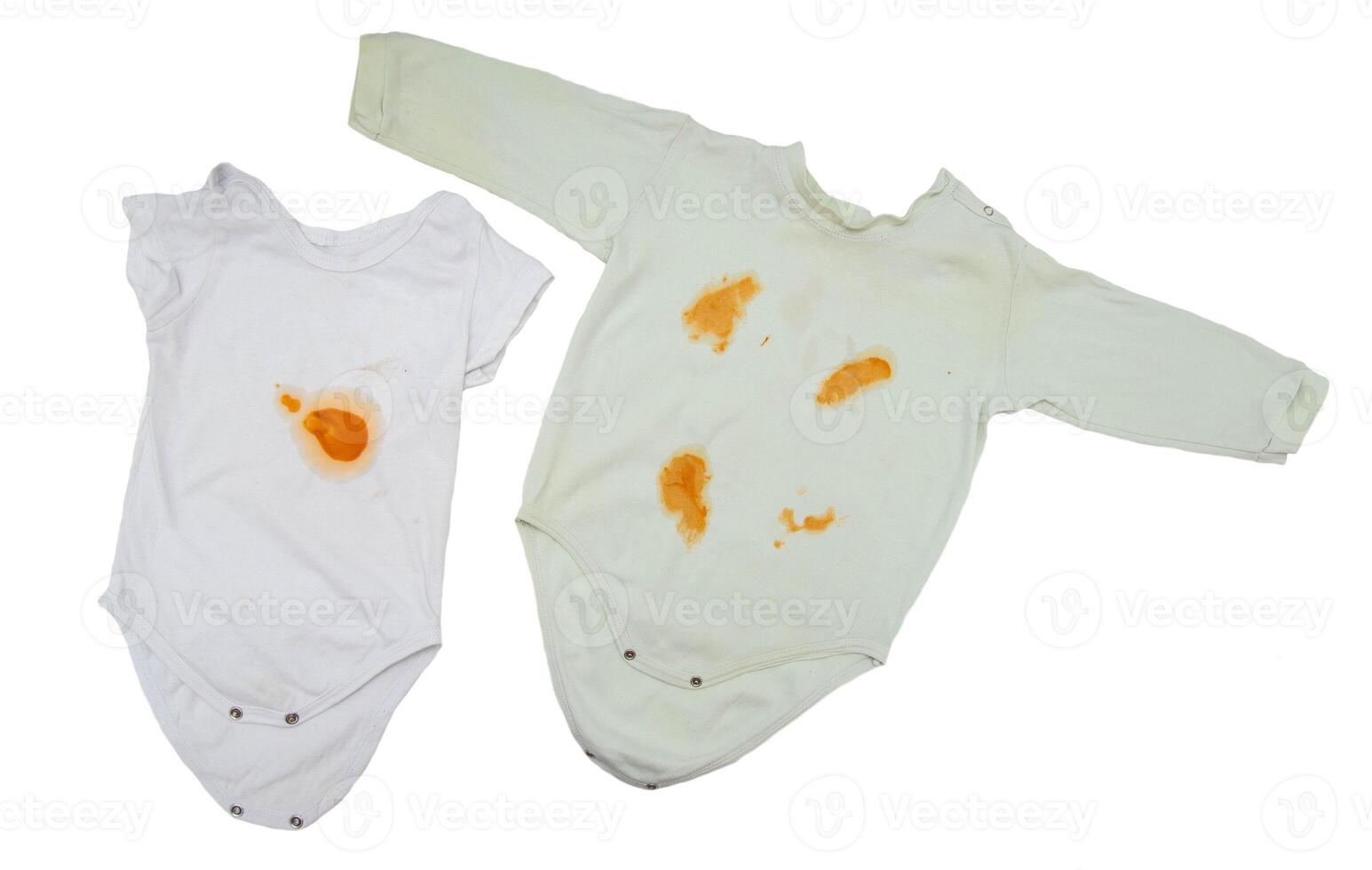 Children's clothing bodysuit with orange stains from vegetable puree on a white background, isolate. Oxygen stain remover concept, close-up photo