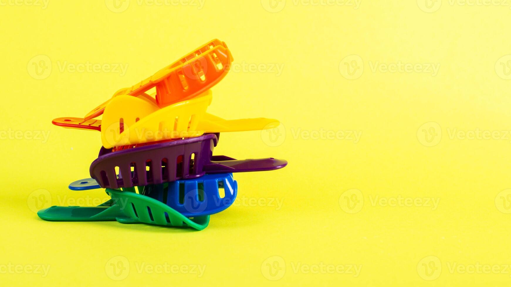 Multi-colored dental spoons for taking an impression of the patient's dental jaw on a yellow background. Manufacturing of crowns and prostheses of the jaw in orthodontics. photo