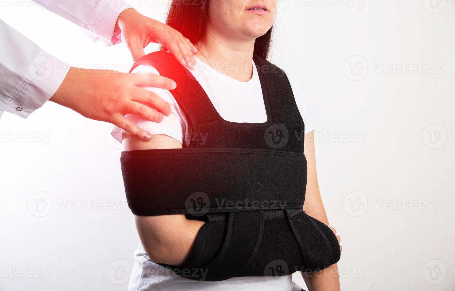 An orthopedic doctor examines a girl patient after a shoulder injury. Bandage on the shoulder joint after shoulder dislocation and bone fracture. Post-traumatic immobilization photo