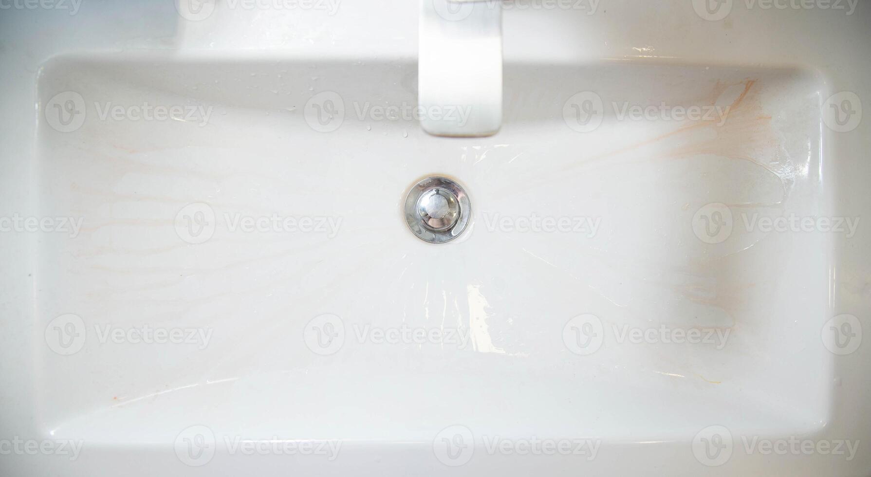 Limescale deposits on the bathroom sink. Cleaning and washing bathroom fixtures. Cleaning services, copy space for text photo