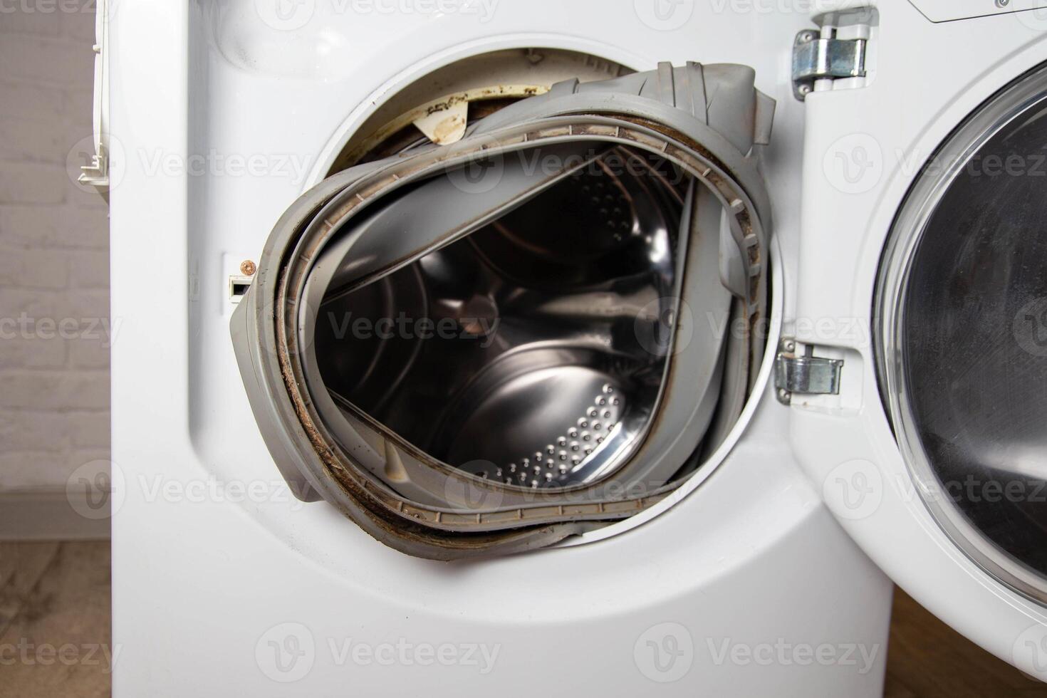 An old torn rubber seal for the sunroof with a defect, in the washing machine. Replacement of faulty spare parts, industry photo