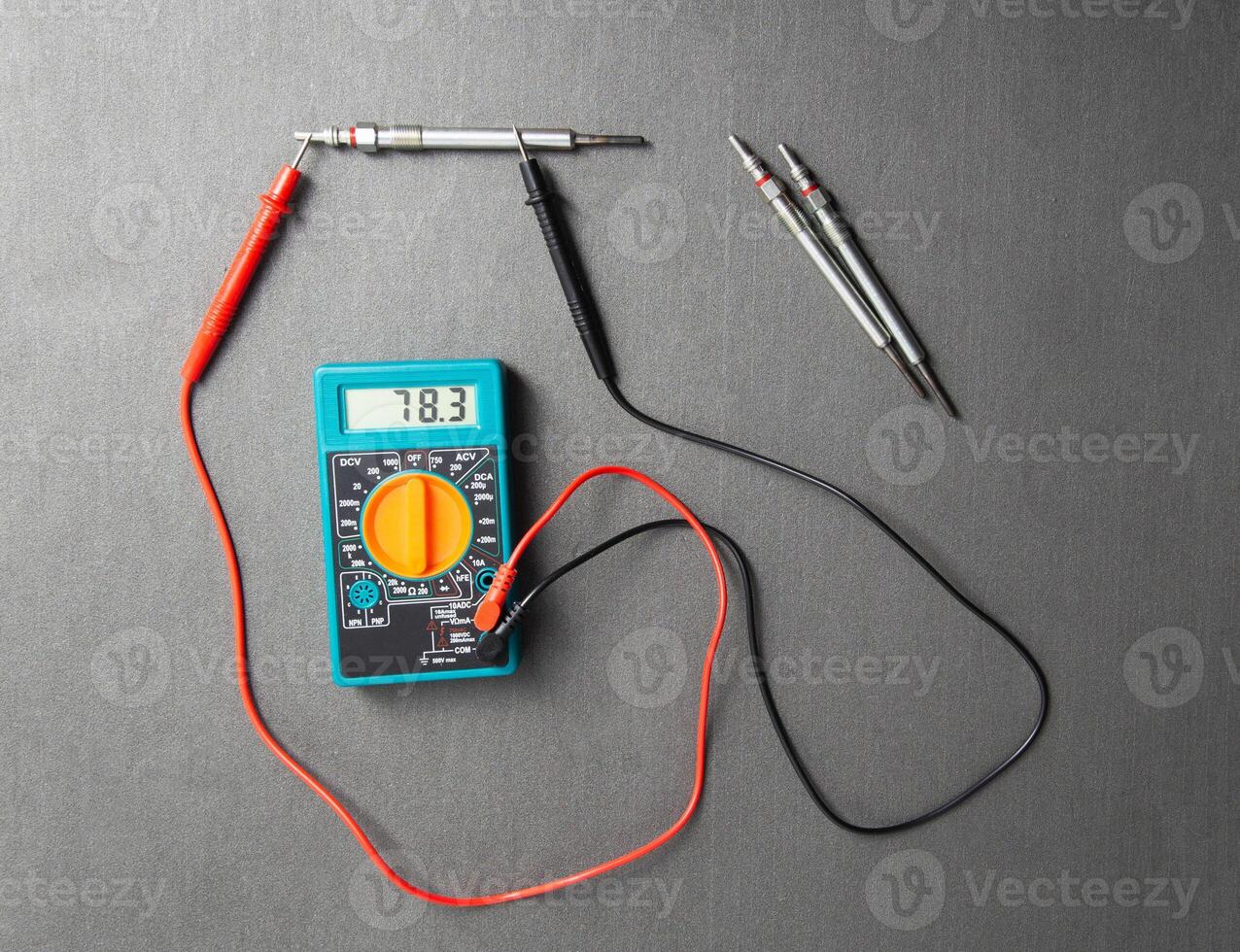 Checking the serviceability of the glow plug with a multimeter. Glow plug voltage resistance. Modern heating element, close-up photo