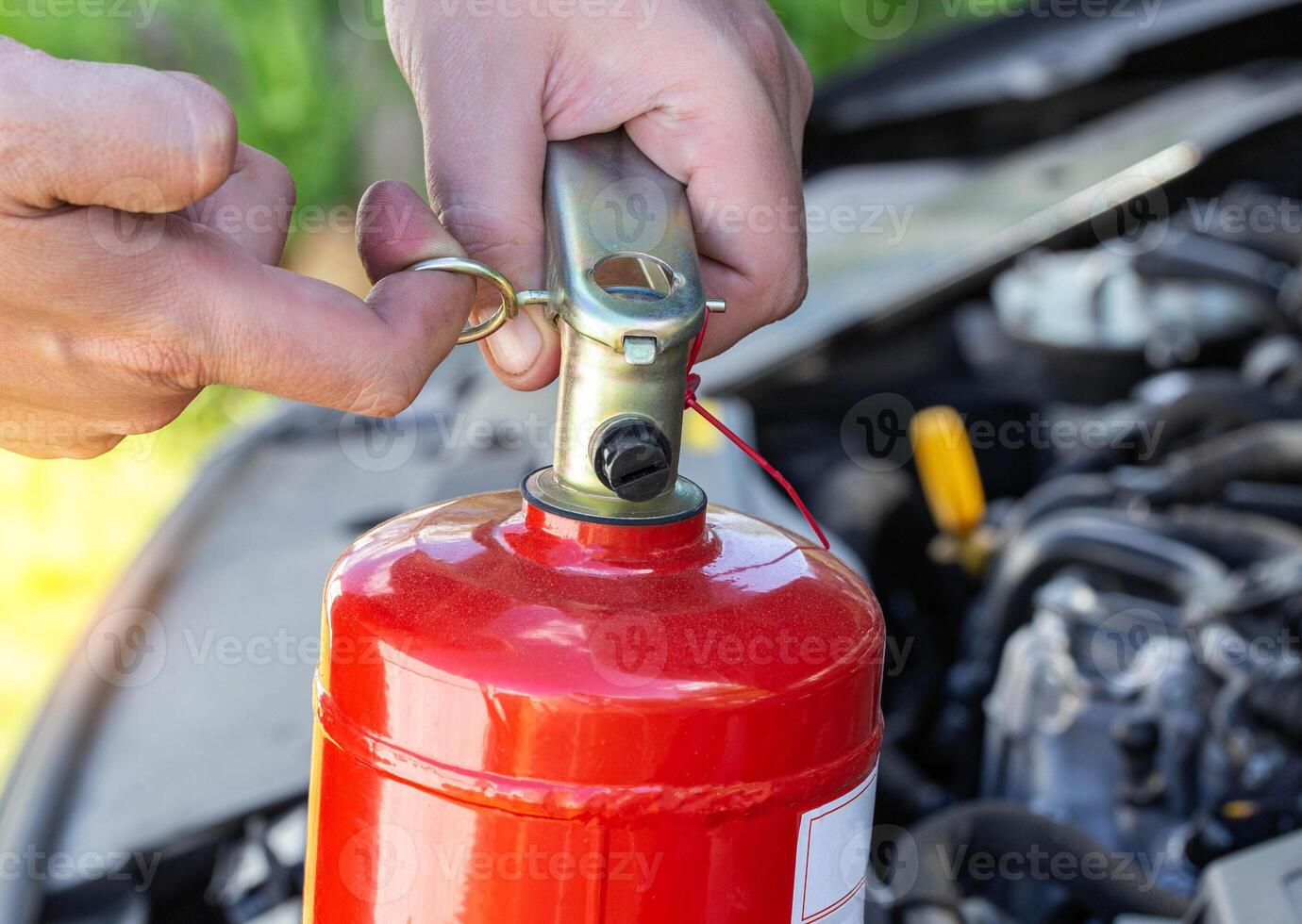 un hombre toma fuera un alfiler desde un coche fuego extintor. el concepto de el vencimiento fecha de un fuego extintor, extinguir un fuego. de cerca foto