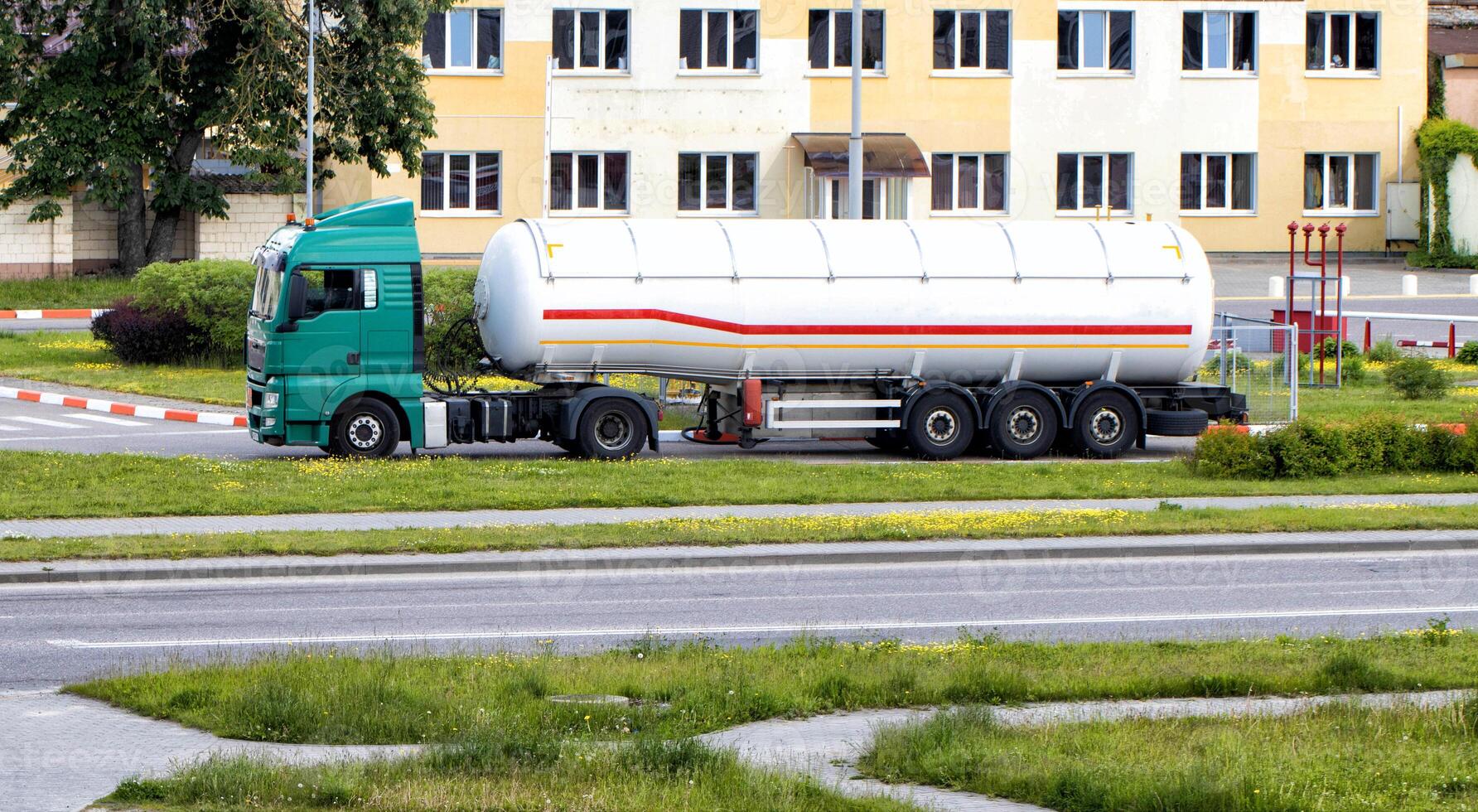 A truck with a semi-trailer tank for the transport of gasoline and diesel drains fuel at a gas station. Dangerous goods, flammable. ADR photo