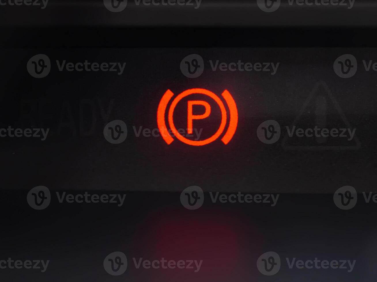 Red parking brake icon on the dashboard of a car. Brake failure. Close-up photo