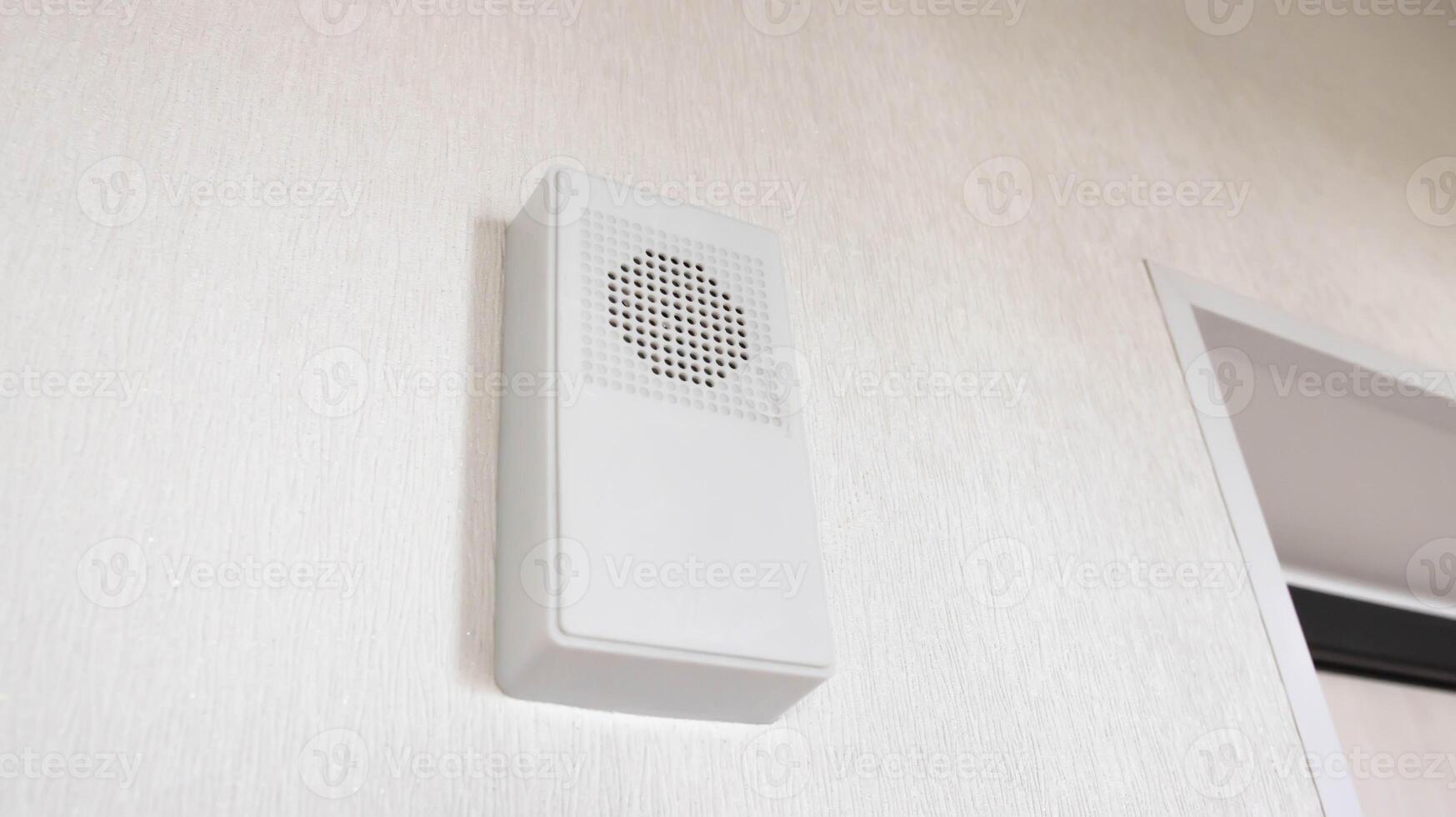 Modern wireless electronic door bell for two-tone tone, close-up. White wall bell. photo