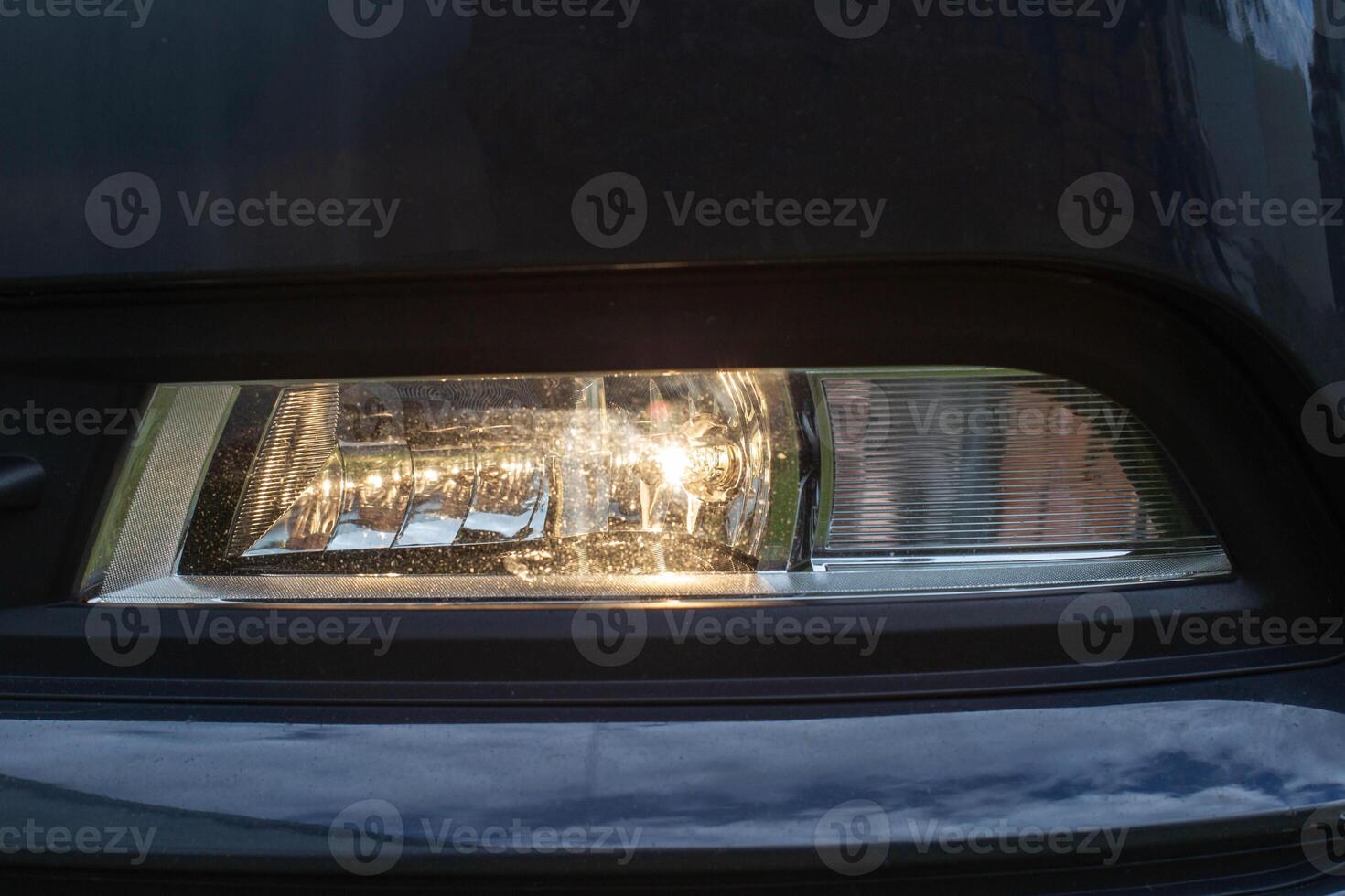 Passenger car fog lamp with yellow light. Close-up photo