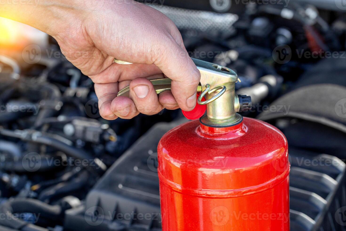 Car fire extinguisher on the background of the car engine. Extinguishing class of fire extinguisher, expiration date. Copy space for text photo