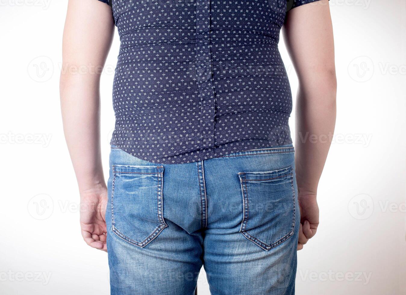 A man in a black tight shirt on a white background. Overweight, unhealthy diet and weight loss concept, close-up. Small clothing size photo