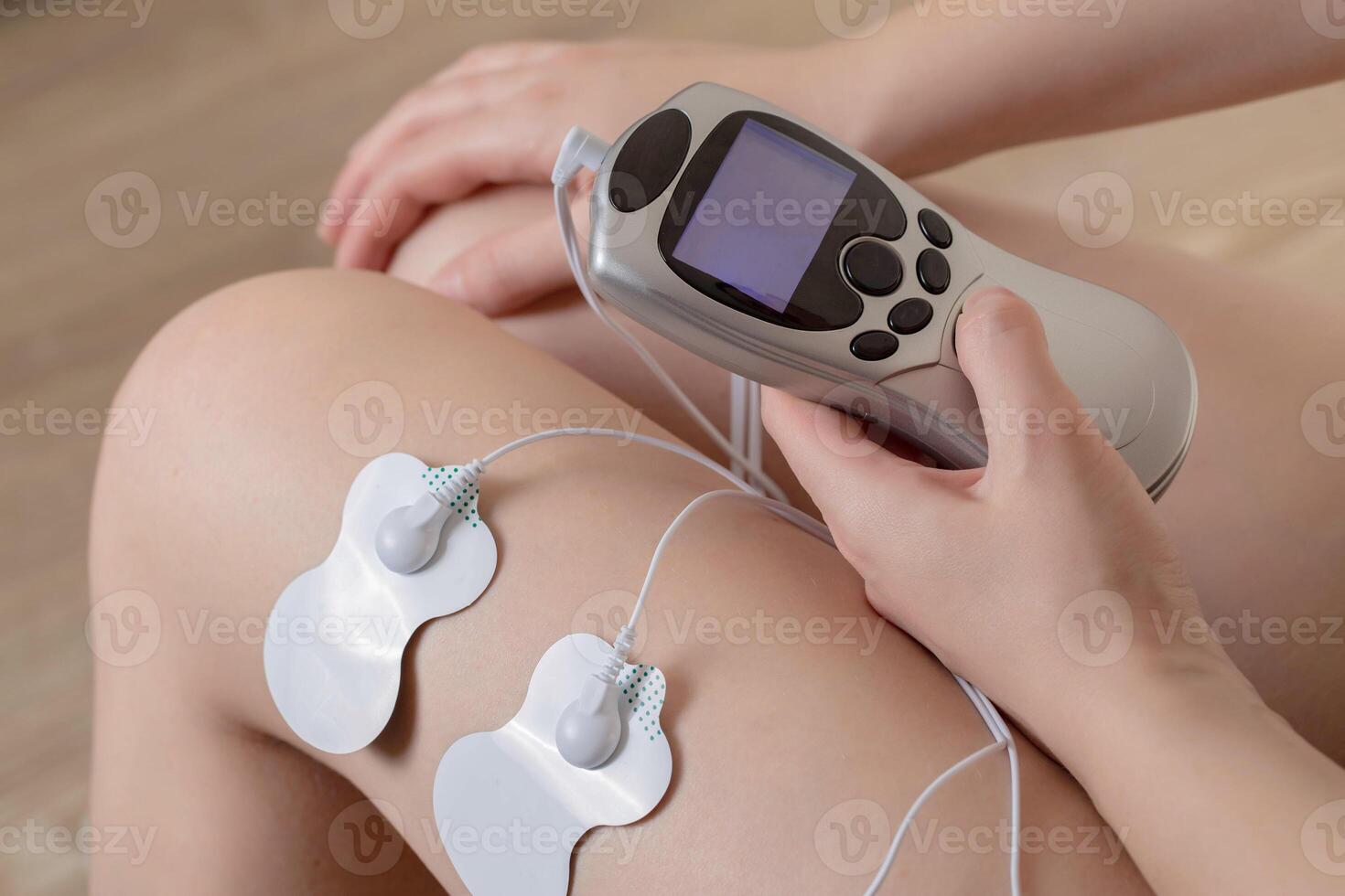 Electrodes of modern acupuncture and anti-cellulite massagers on the legs of a girl in problem areas. Home physiotherapy, close-up photo