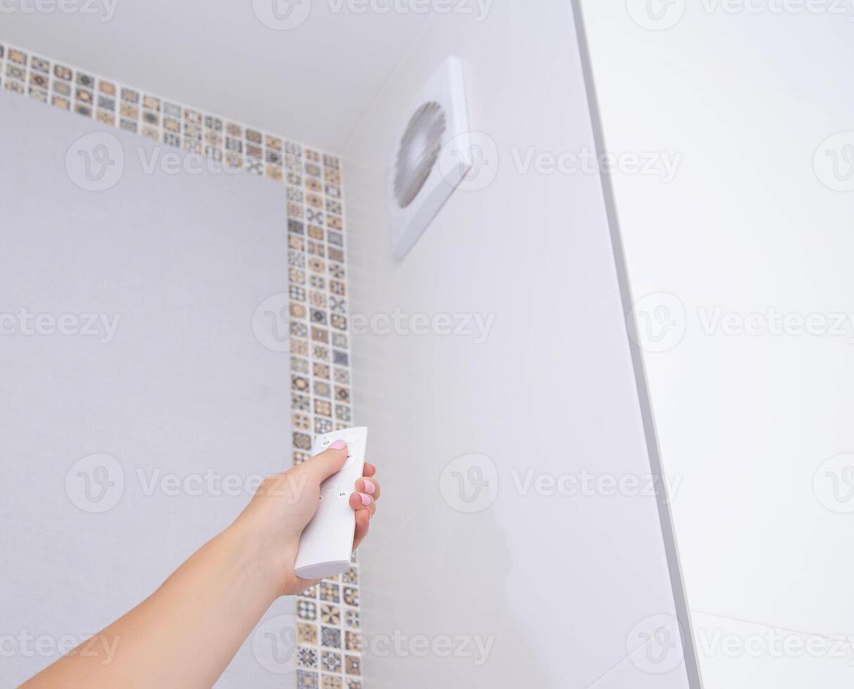 Modern exhaust fan in the bathroom with remote control for blade speed and power. Airing the room, domestic photo
