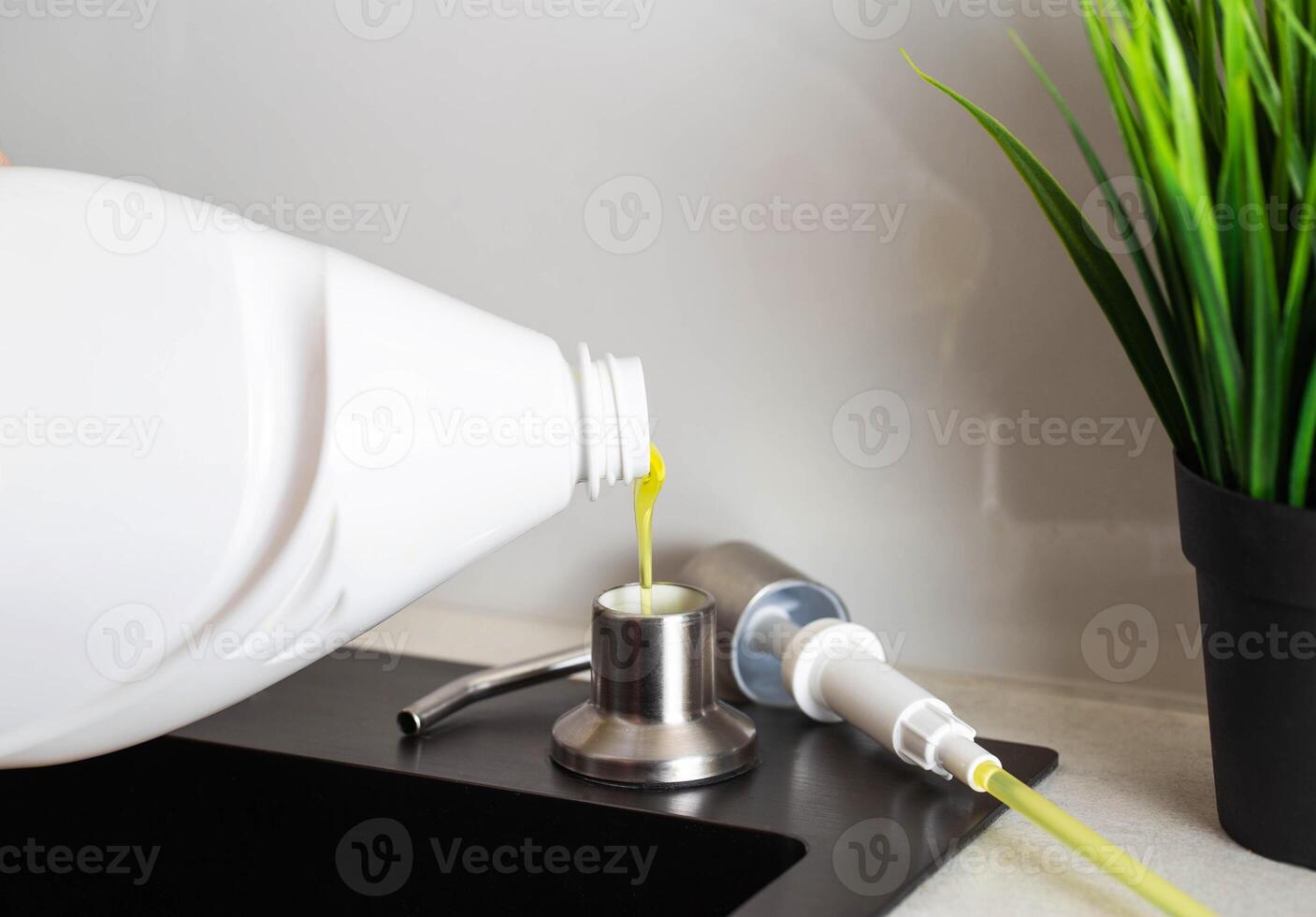 Dismantled detergent dispenser built into the sink. Adding soap to the dispenser. Copy space for text photo