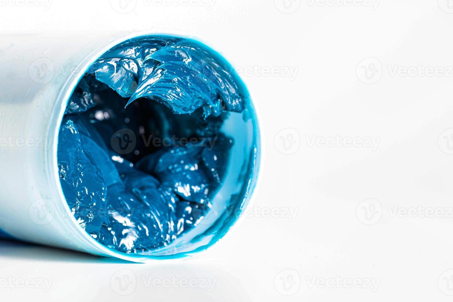 Tube with blue automotive high temperature grease on a white background, isolate. Copy space for text, industry photo