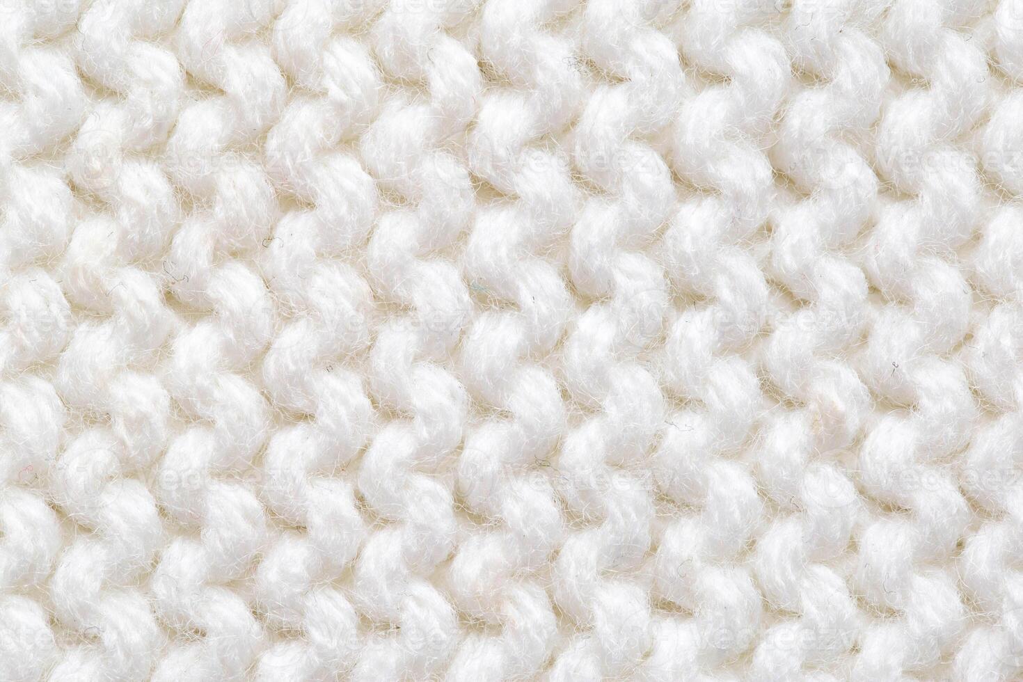 Comfortable warm knitted sweater made of white threads, background. Macro, handmade photo