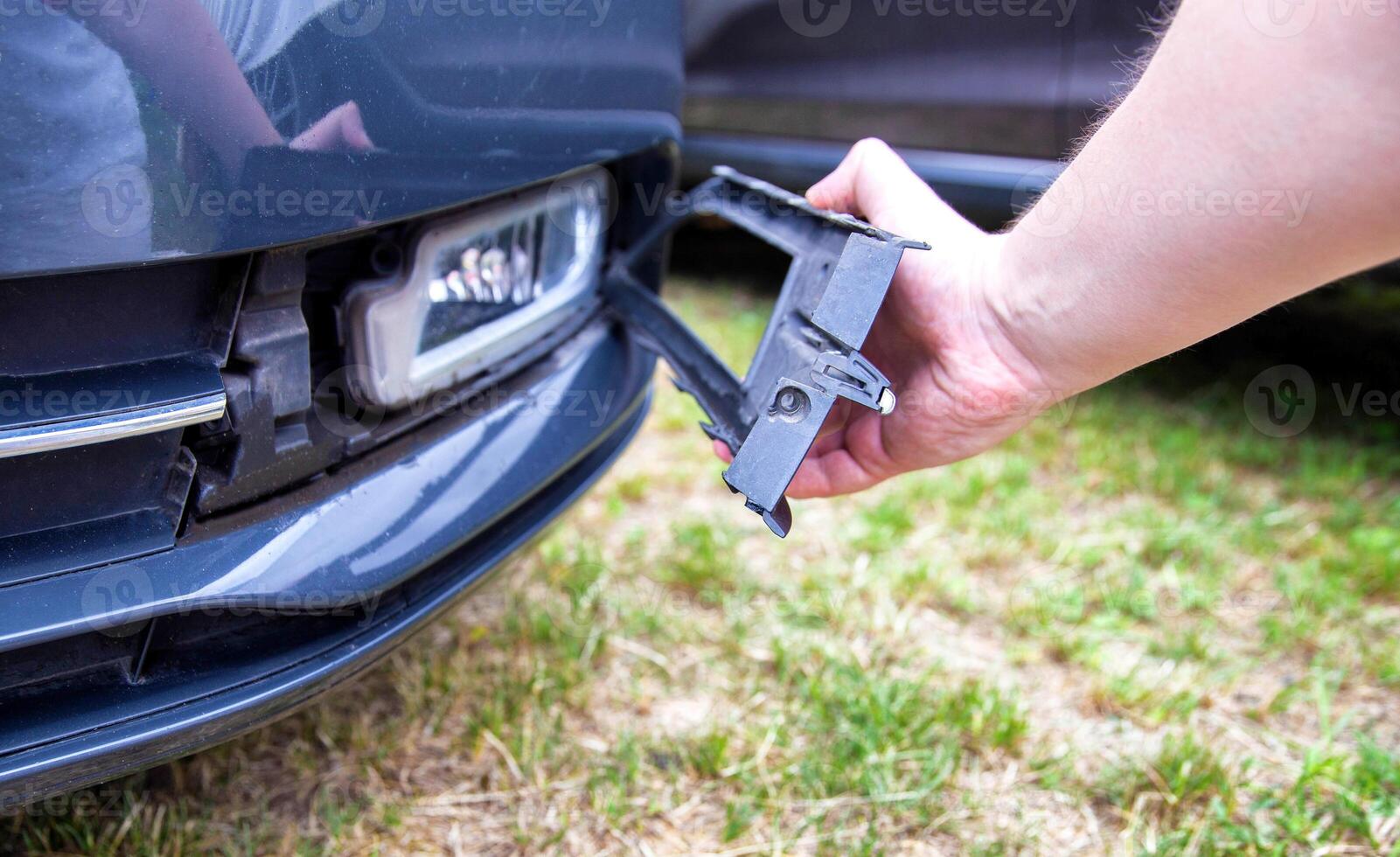 Disassembling and removing the fog lamp from a car to replace a burnt out light bulb. Close-up photo