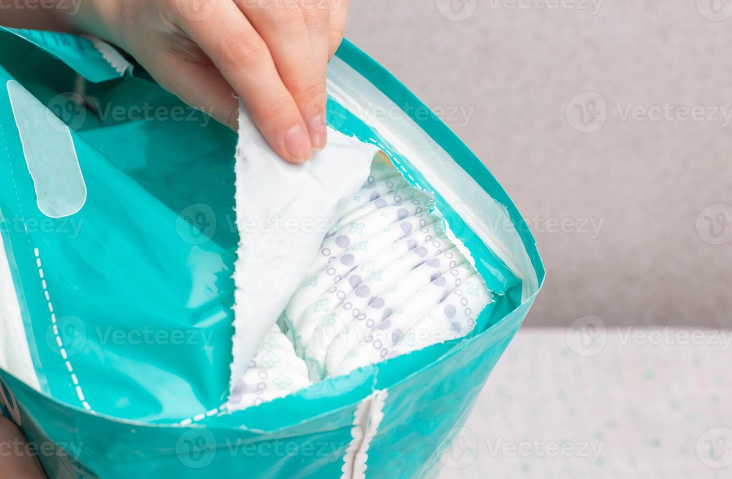 Unpacking a whole package of baby diapers on a white background. Copy space for text photo
