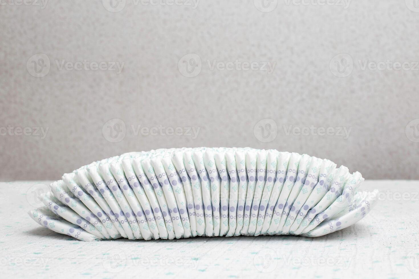 A stack of many diapers on a white background. Copy space for text photo