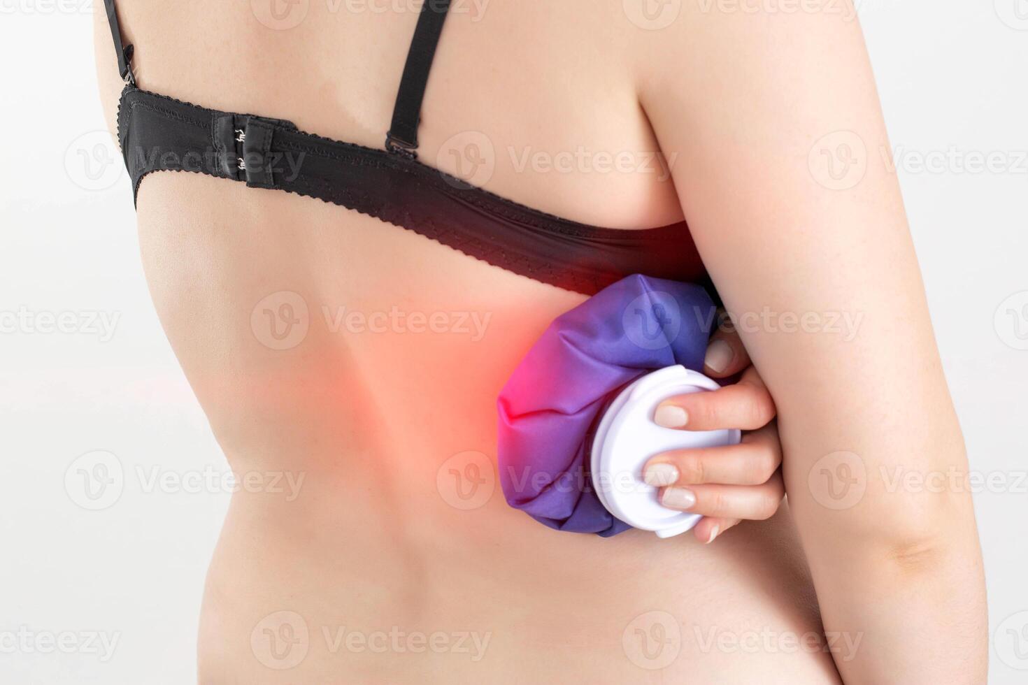 The girl holds a compress with a cold for pain of intercostal neuralgia, pinched nerve. Cold treatment of bruises and bruises, ligament rupture photo