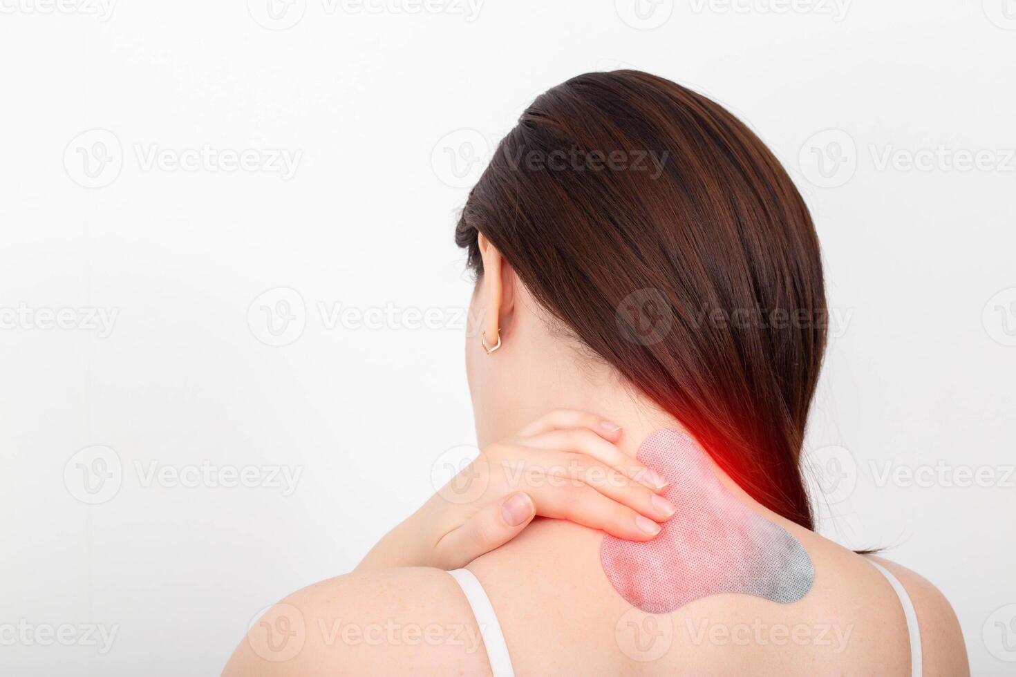 Medical anesthetic plaster on the cervical spine of a girl. Muscle spasm and pain treatment concept. Copy space for text photo