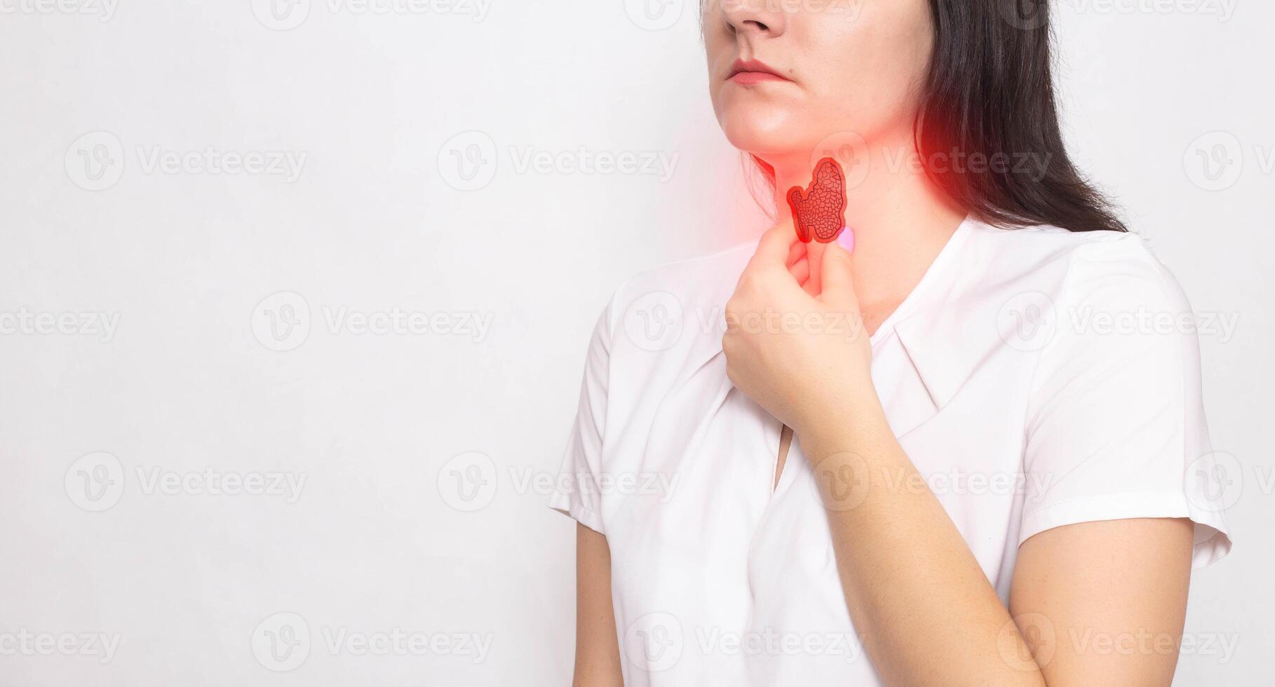 The girl holds her neck with a thyroid gland with her hand on a white background. Thyroid diseases and problems concept, lack of iodine in the body, copy space for text photo