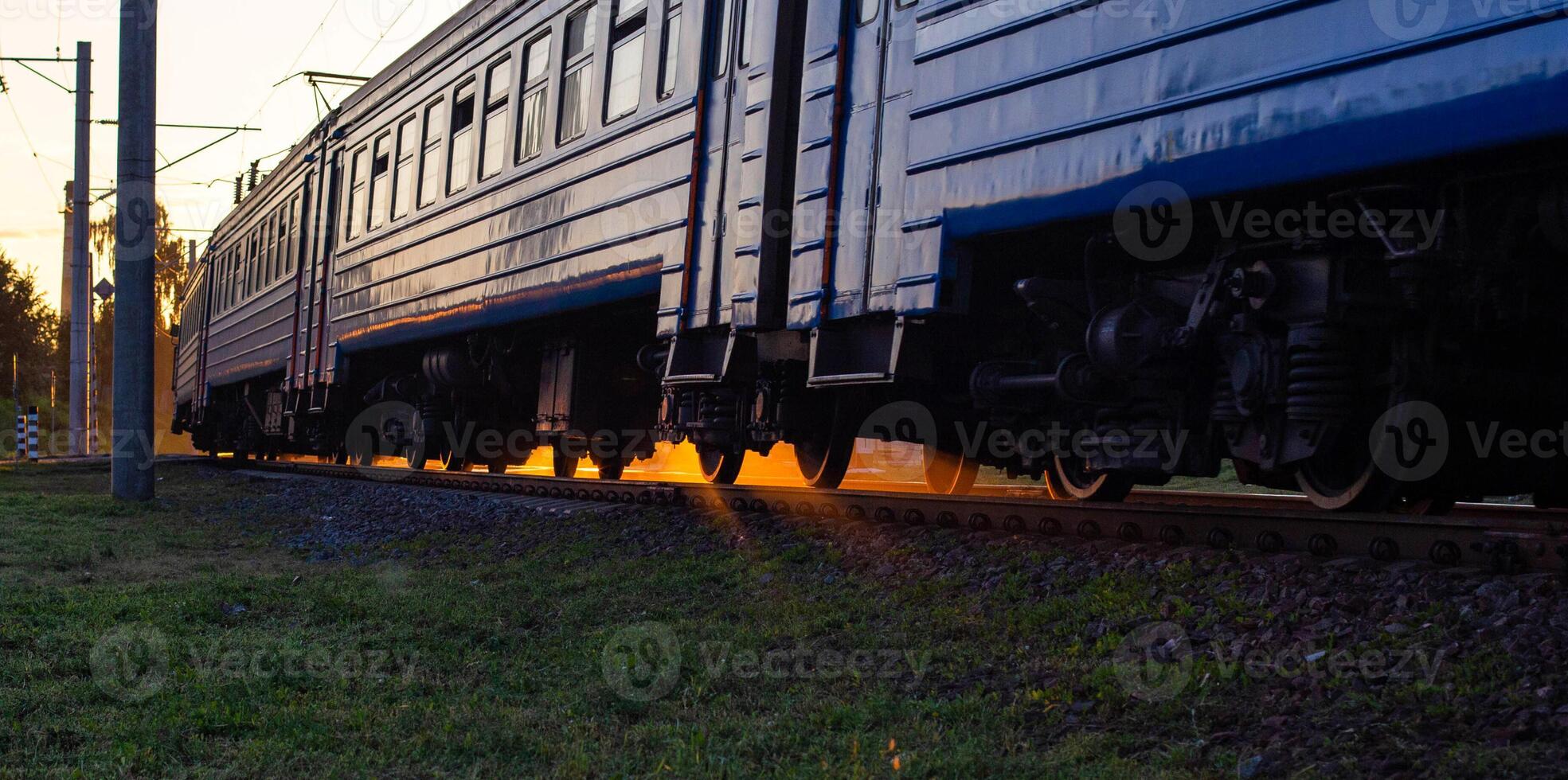Passenger train electric train on the background of a sunny sunset, evening time. Railroad passenger transportation concept, copy space for text photo