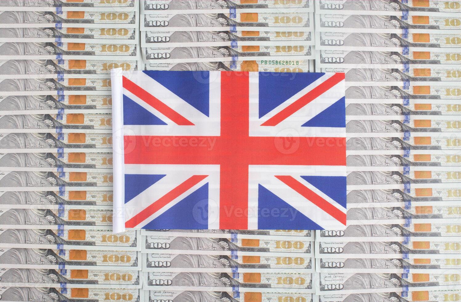 United Kingdom flag on a background from dollar banknotes. Concept of the relationship of the British money in relation to the dollar, the country's economy, financial photo