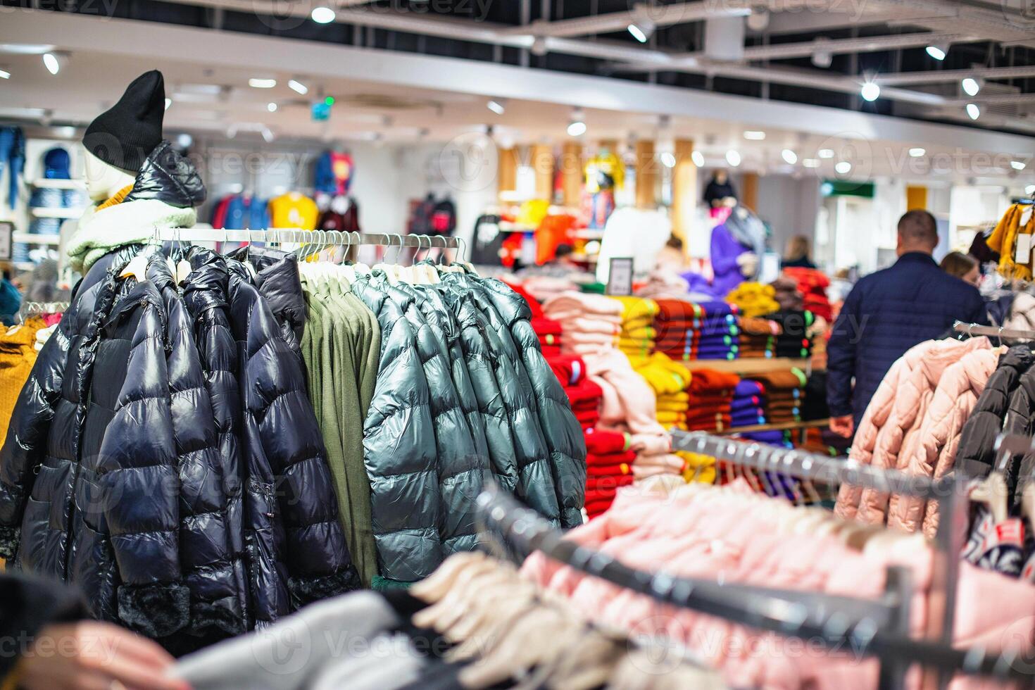 Sale in a store of fashionable and stylish winter clothes. Warm things jackets and sweaters, background, shopping photo