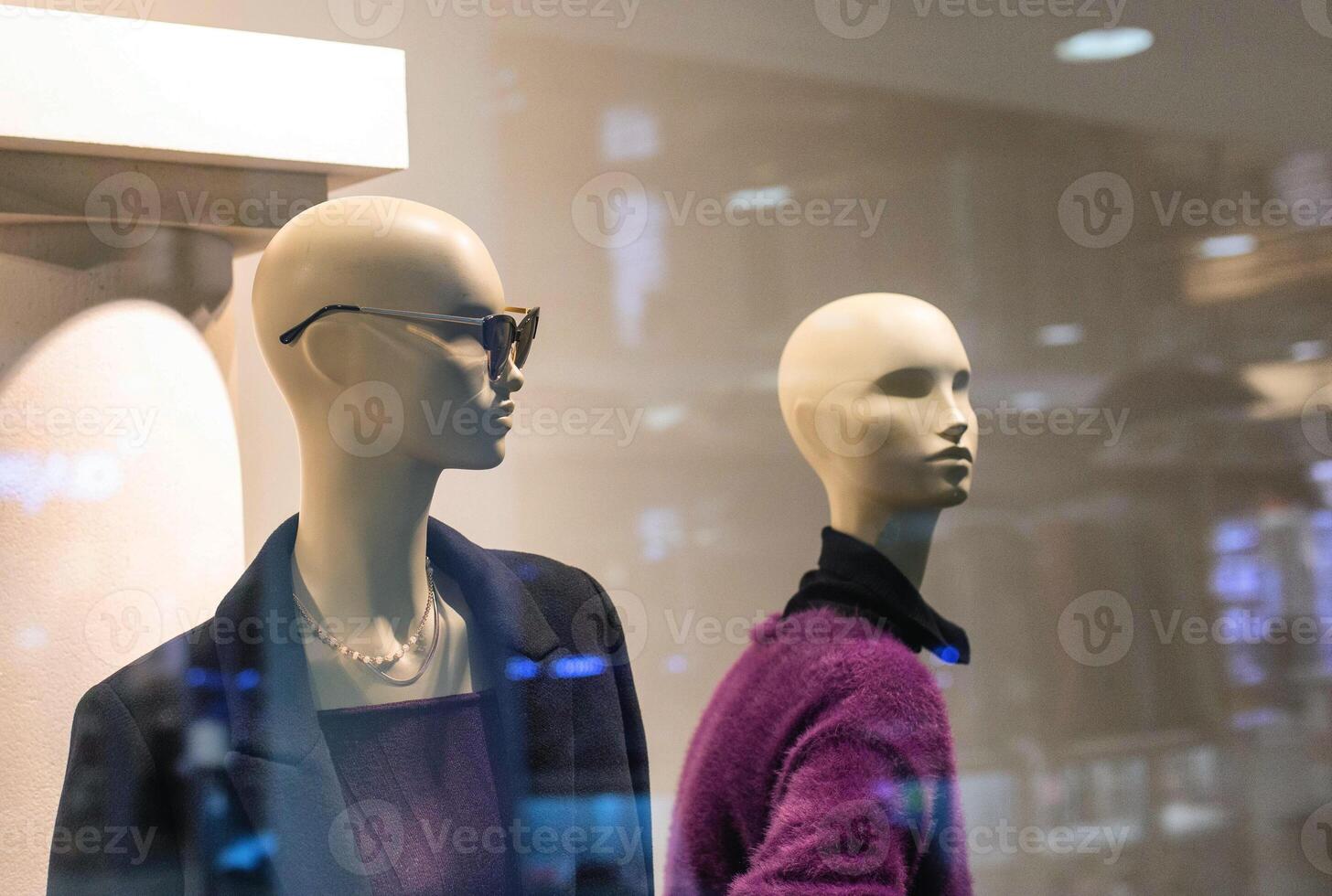 Two fashionable and stylish mannequins in modern glasses and warm business clothes. The concept of selling quality and stylish clothes, background photo