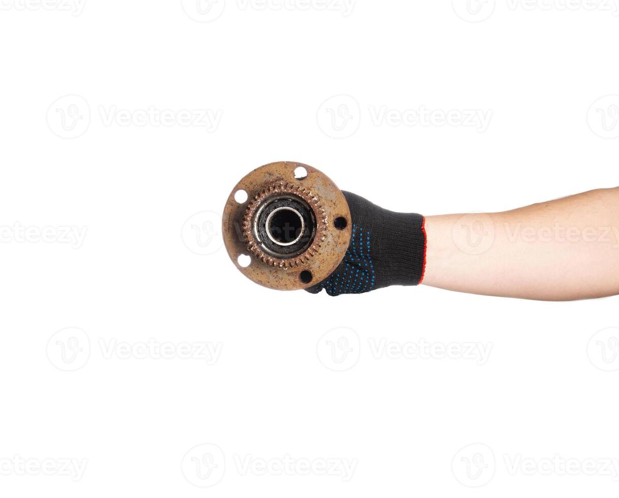 Rusty old hub with a bearing in the hand of a car mechanic on a white background, isolate. Repair and replacement of the hub, close-up photo
