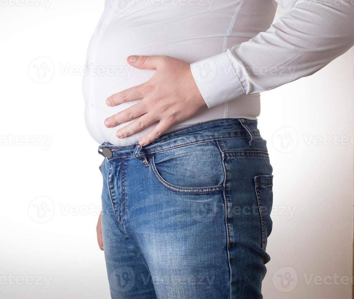 A fat man in a small, tight white shirt. Uncomfortable clothing concept, obesity. Slimming photo
