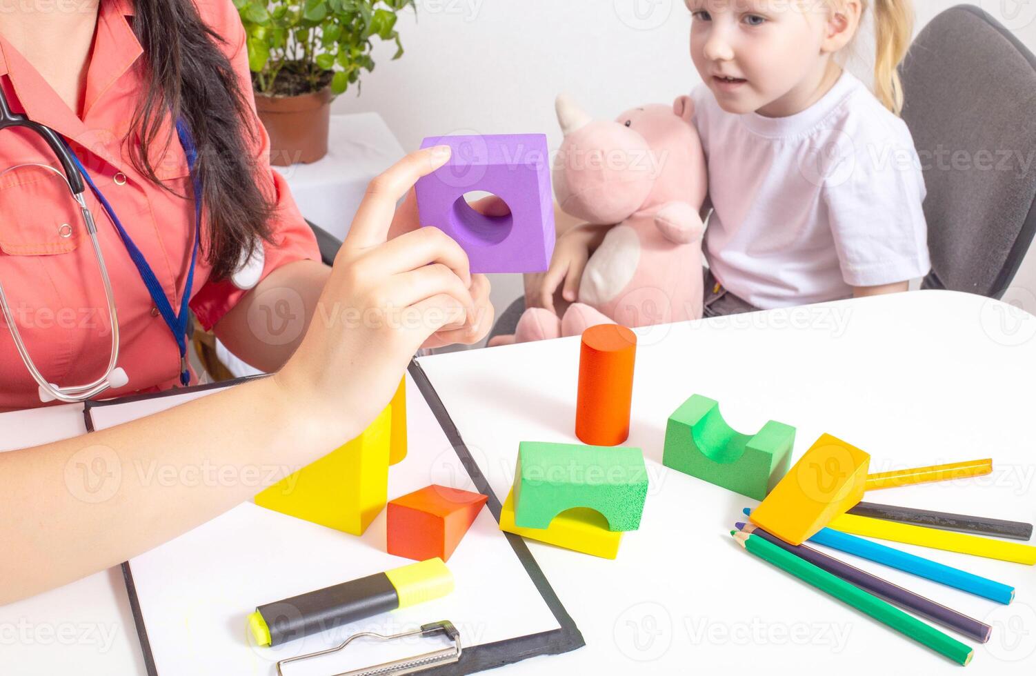 Woman doctor pediatrician plays colorful cubes with a 3-4 girl. Children's health, background photo